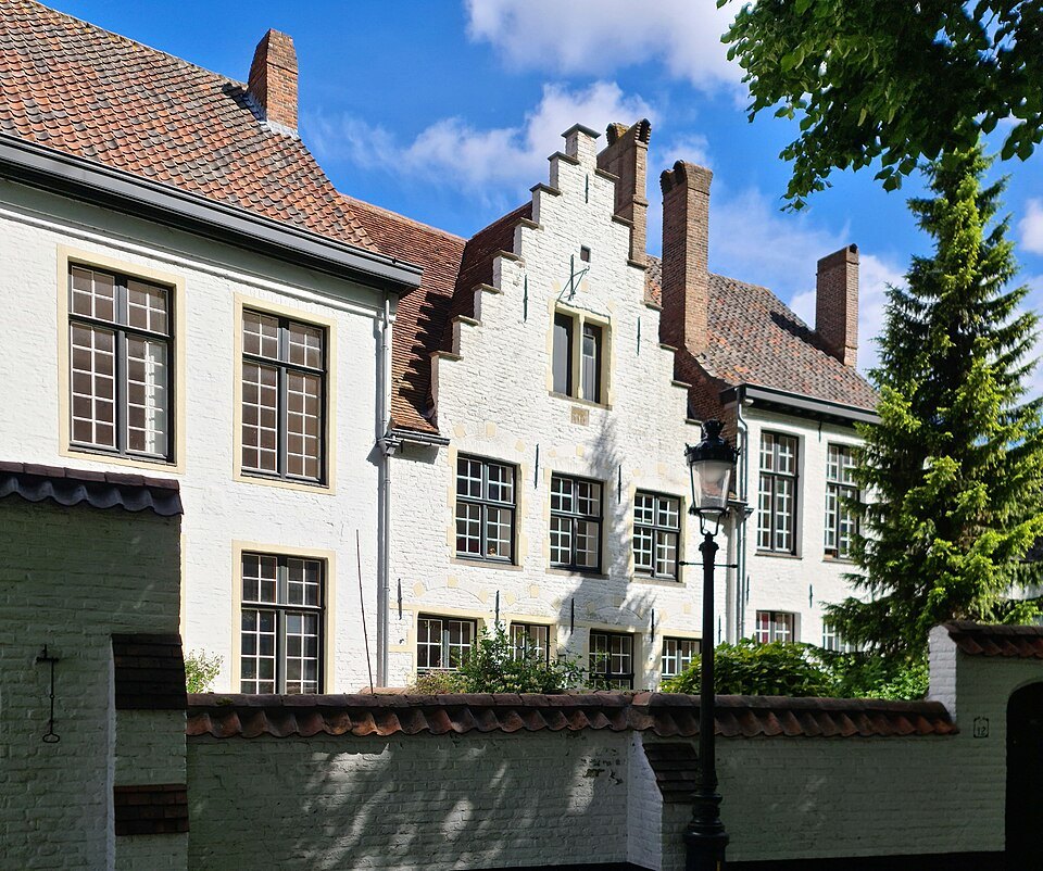 A stepped gable and white-framed windows on a house in the Beguinage