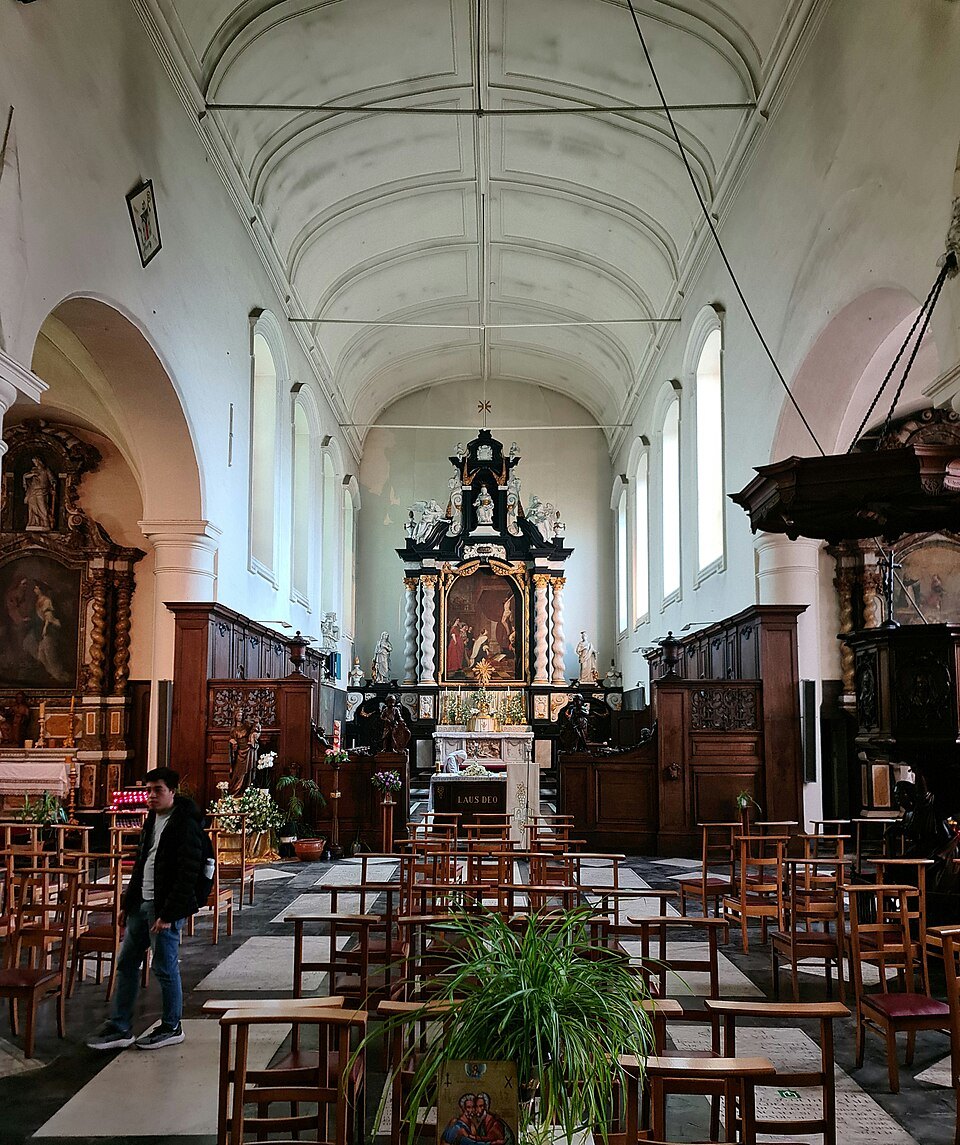 The white interior of the Beguinage church, looking towards the altar