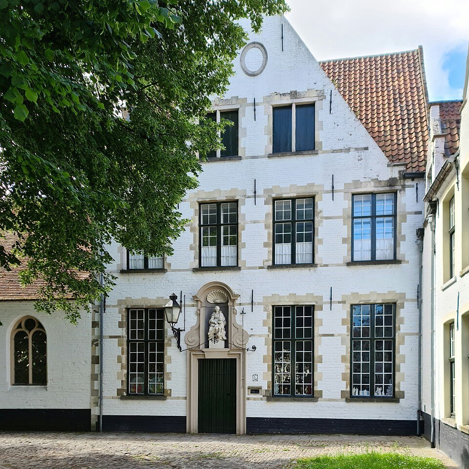 A white house with a small statue above its doorway