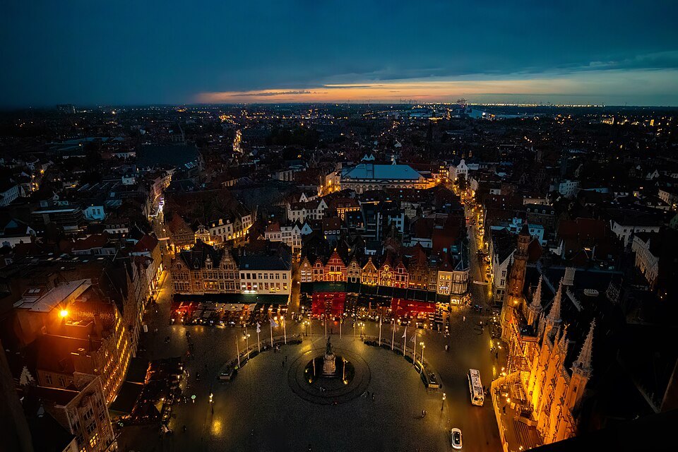 Bruges from high above after dusk, the Markt lit below