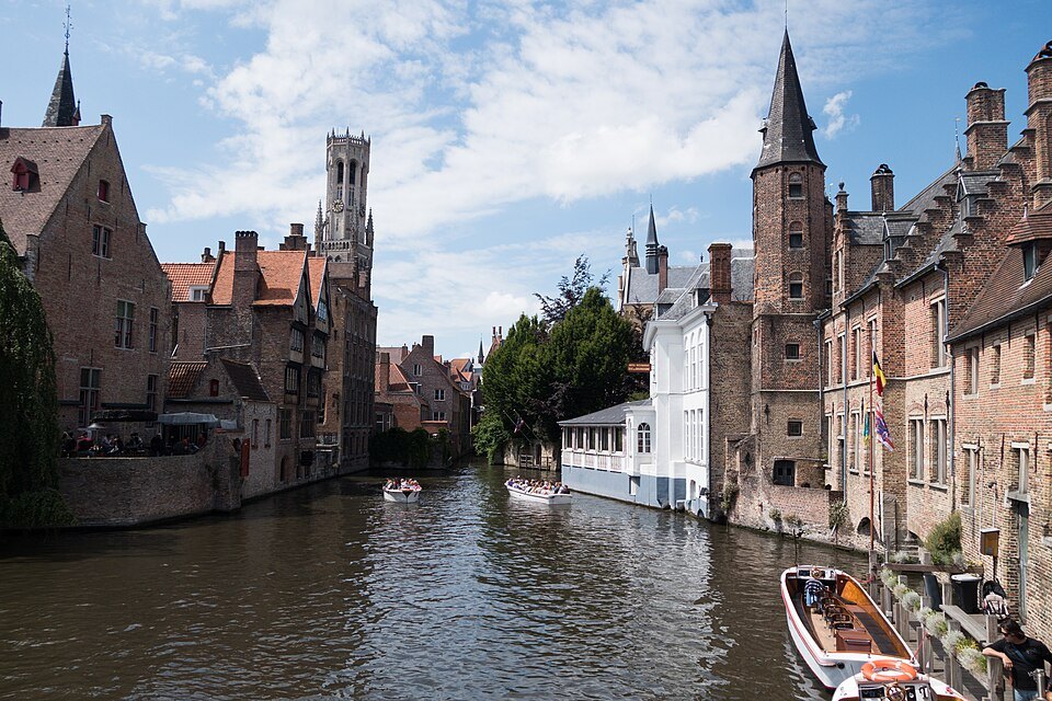 Canal boats on the water by the Rozenhoedkaai, the Belfry above the roofs
