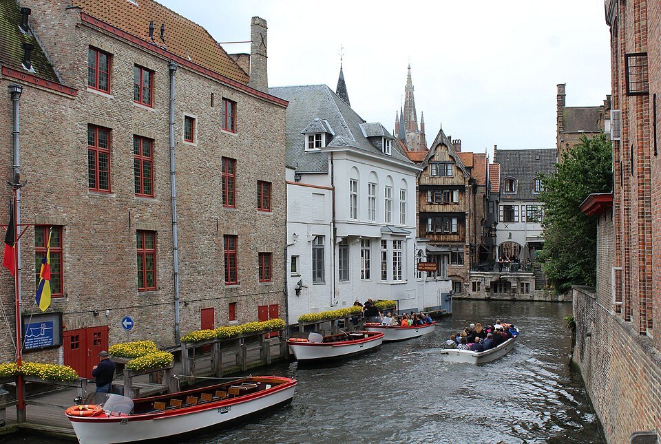 Boats waiting below flower-lined steps along the canal