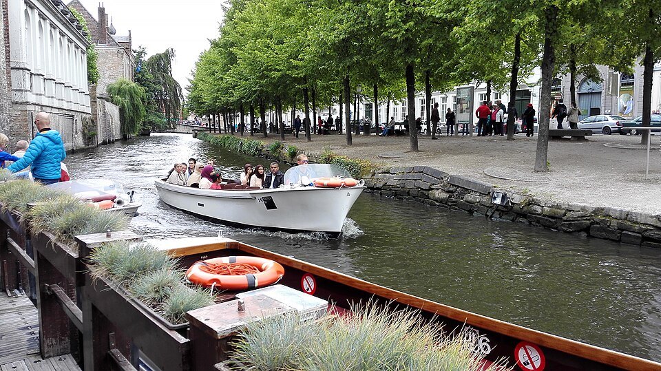 Tour boats and a life ring on the tree-lined Dijver