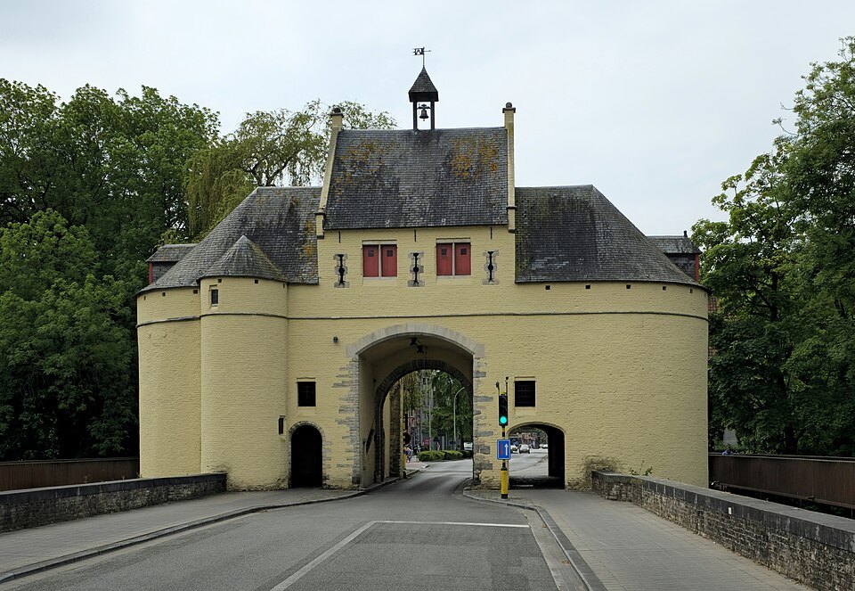 The yellow-rendered Smedenpoort with its small bell turret, the road running through
