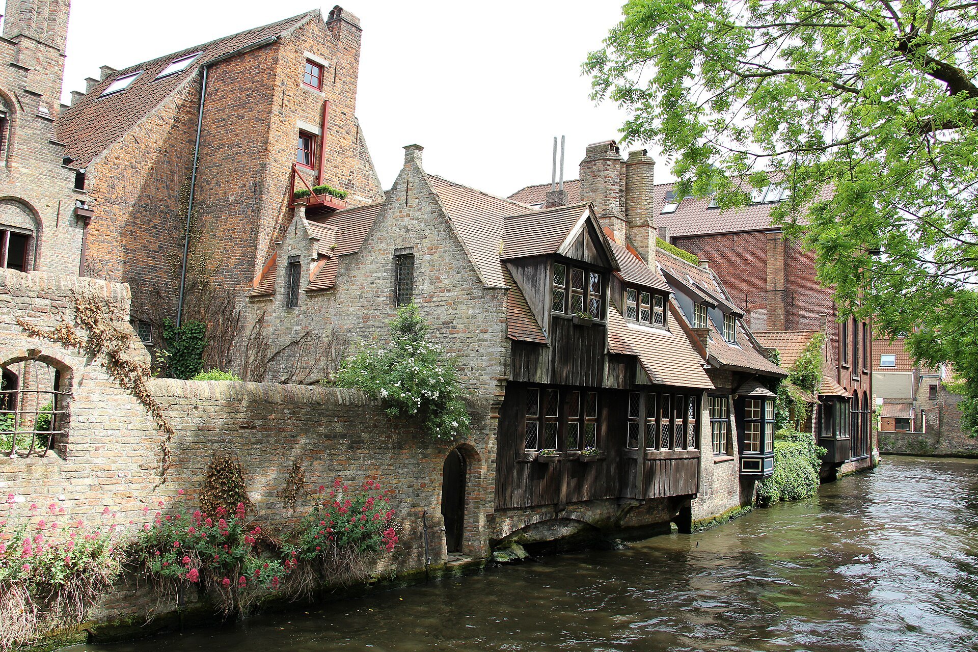 Brick and timber houses rising from the canal behind the Arentshof