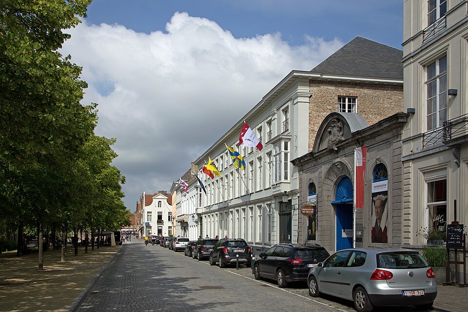 The tree-lined street of the Dijver, flags over the College of Europe