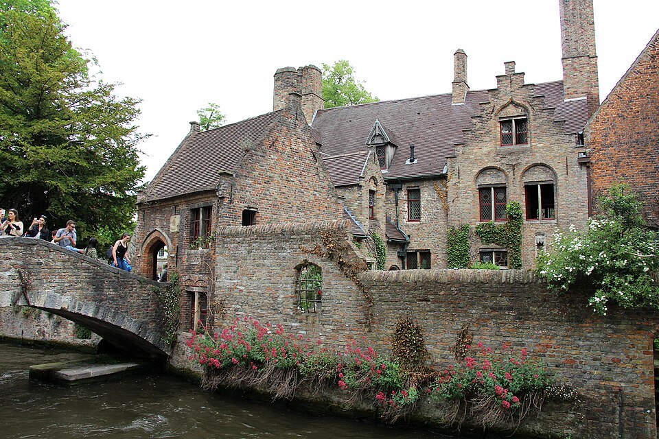 The Bonifacius footbridge and brick houses above flowering walls