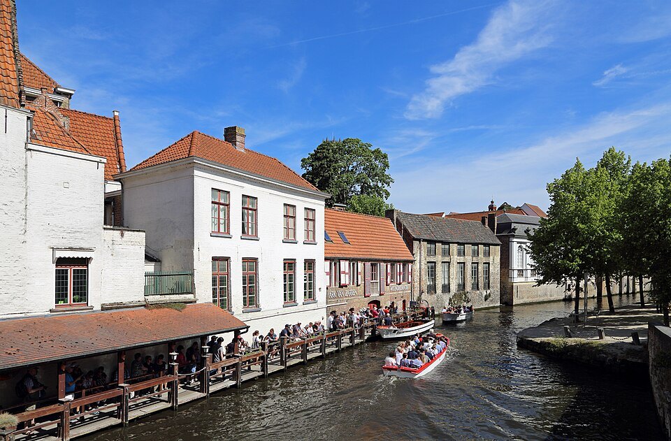 Tour boats on the Dijver beside a landing stage and white-fronted houses
