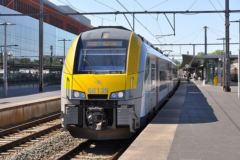 A yellow-nosed train at a platform in Brugge station