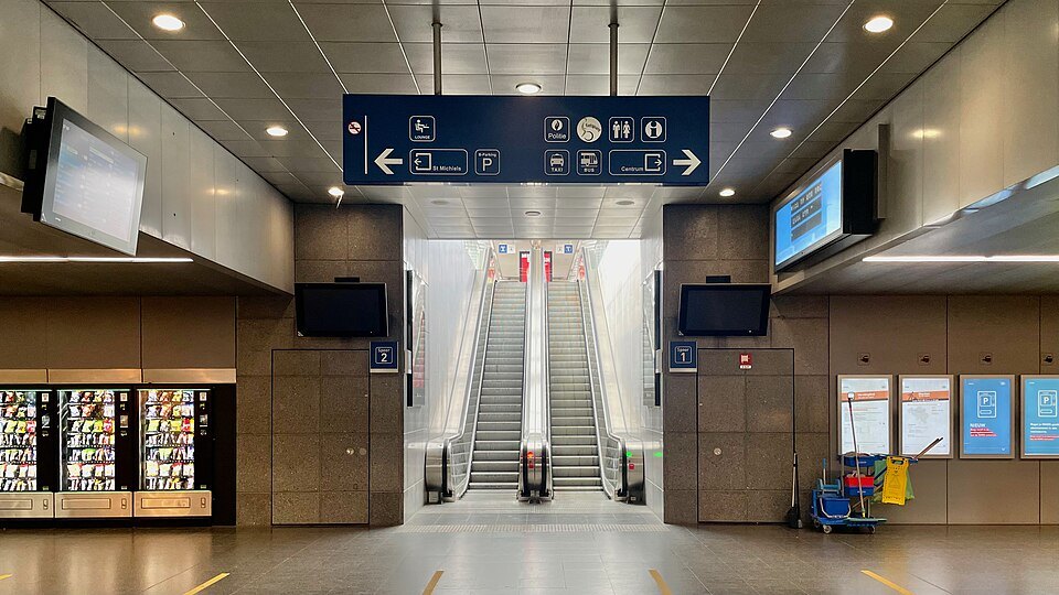 Escalators and signs leading to the platforms in Brugge station
