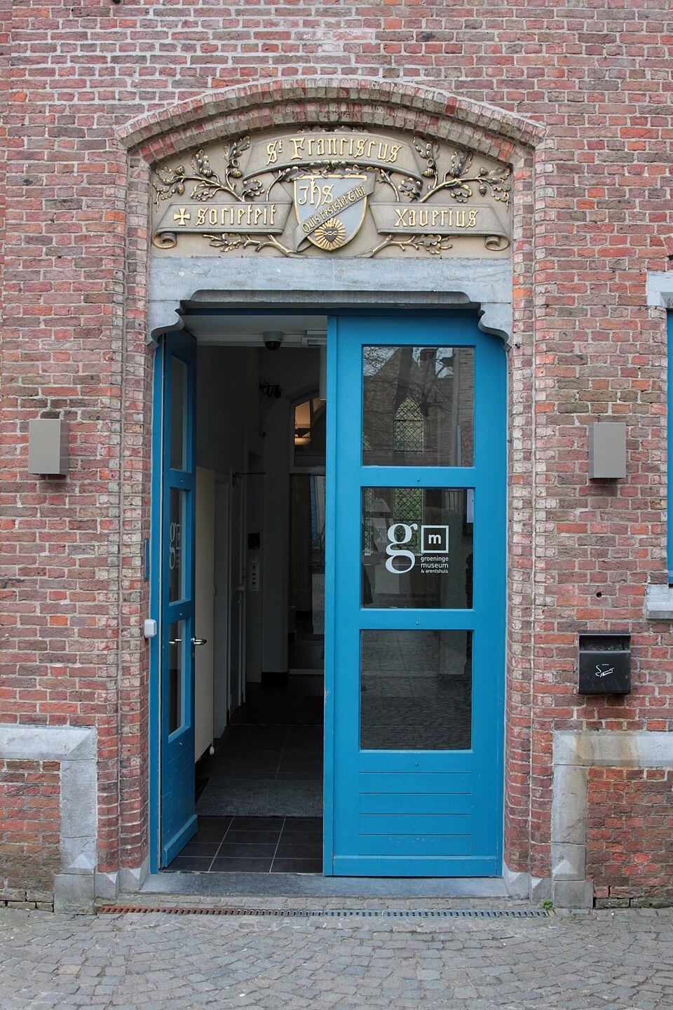 A blue door in a carved stone frame at the Groeningemuseum