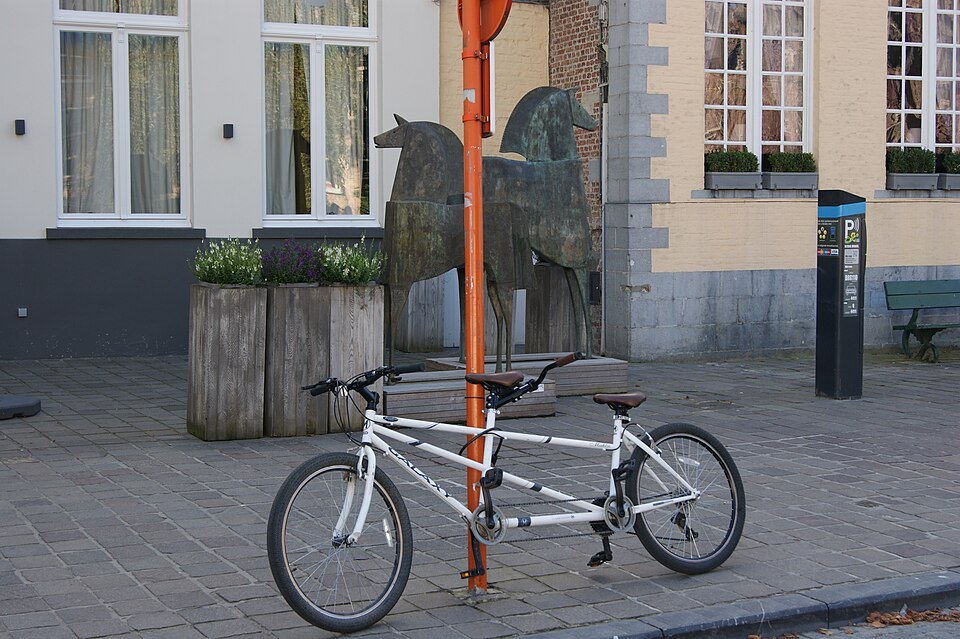 A tandem bicycle parked on a quiet street