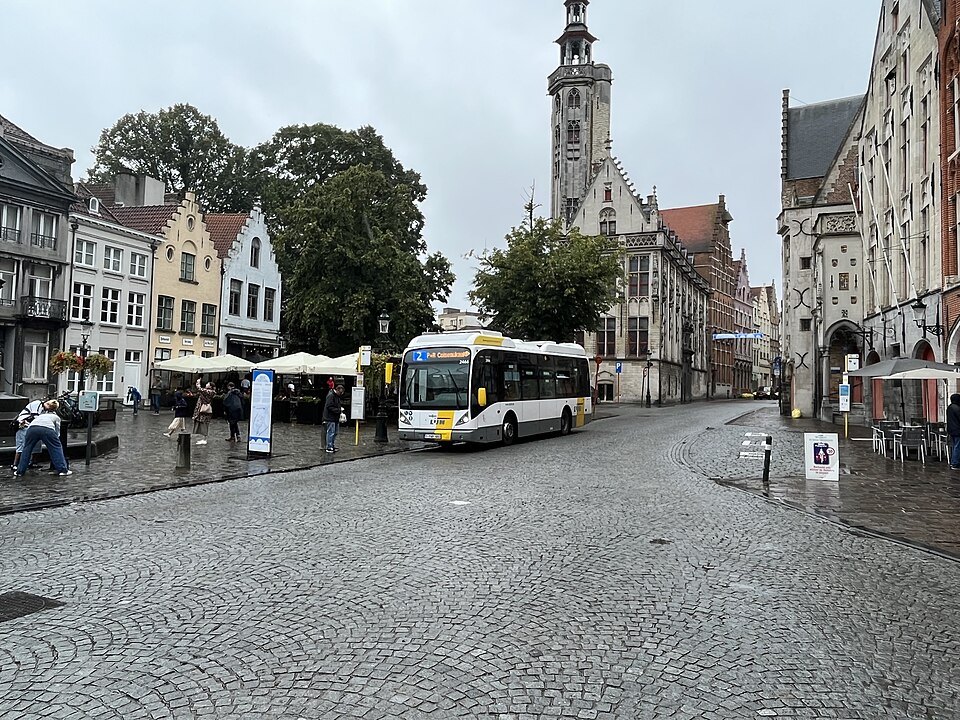 A De Lijn bus crossing a cobbled square in the center