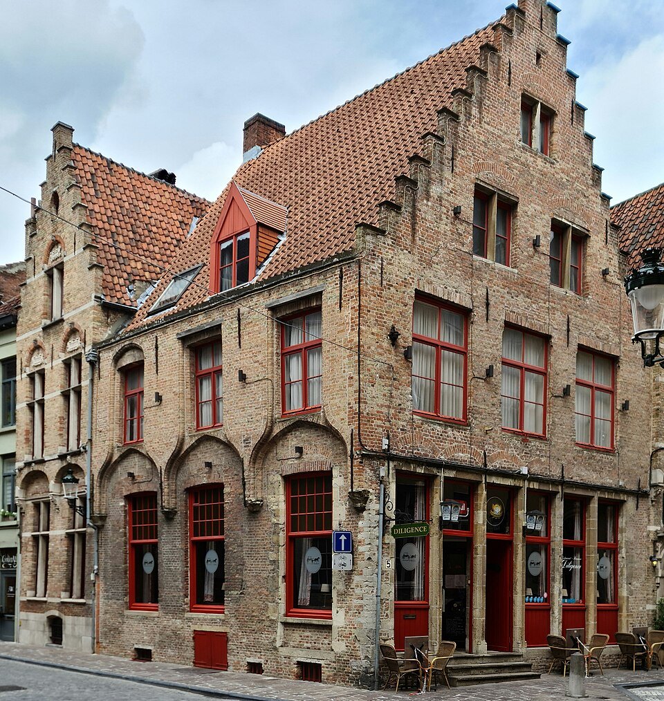 A stepped-gable brick house with red shutters on Hoogstraat