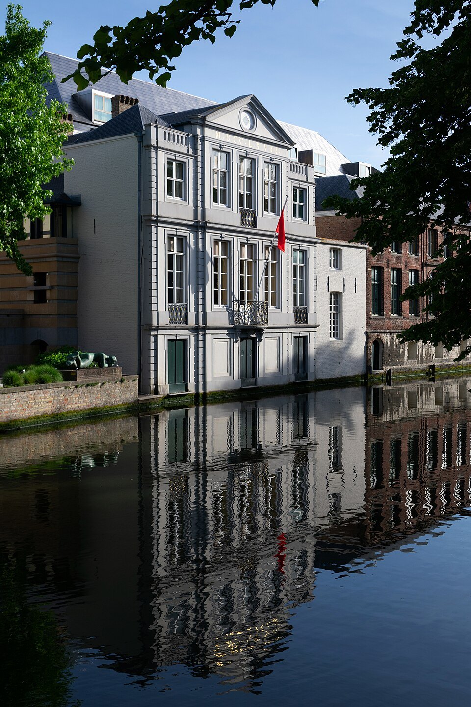 The back of a classical house reflected in a still canal