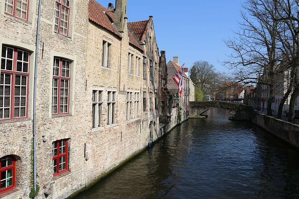 Stone houses with red window frames stepping straight down to the water