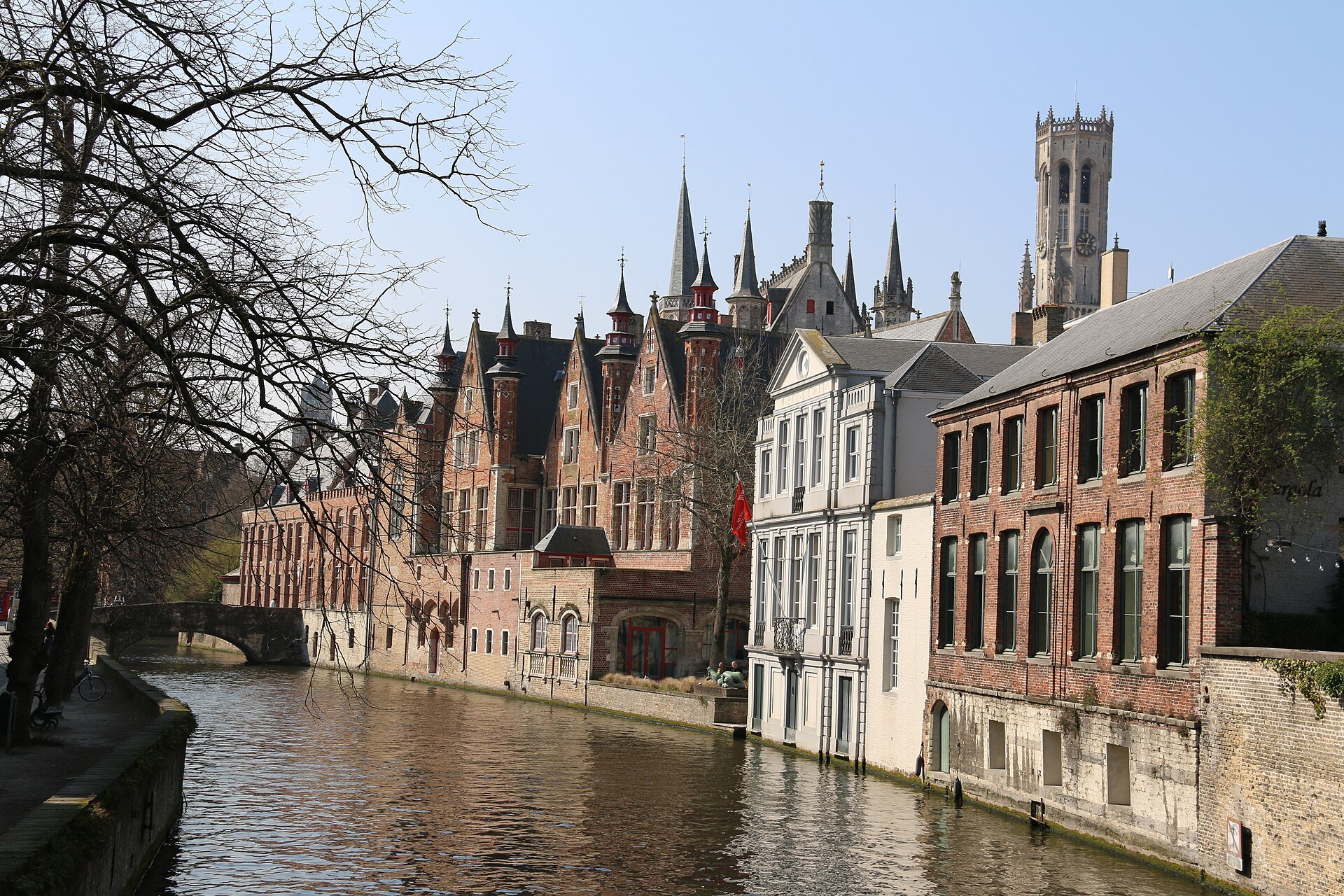 The Groenerei curving past brick houses, with the Belfry and the spires of the Burg behind