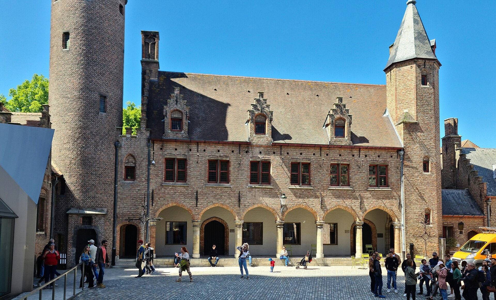 The Gruuthuse courtyard: an arcade of stone arches, a round stair tower and stepped gables
