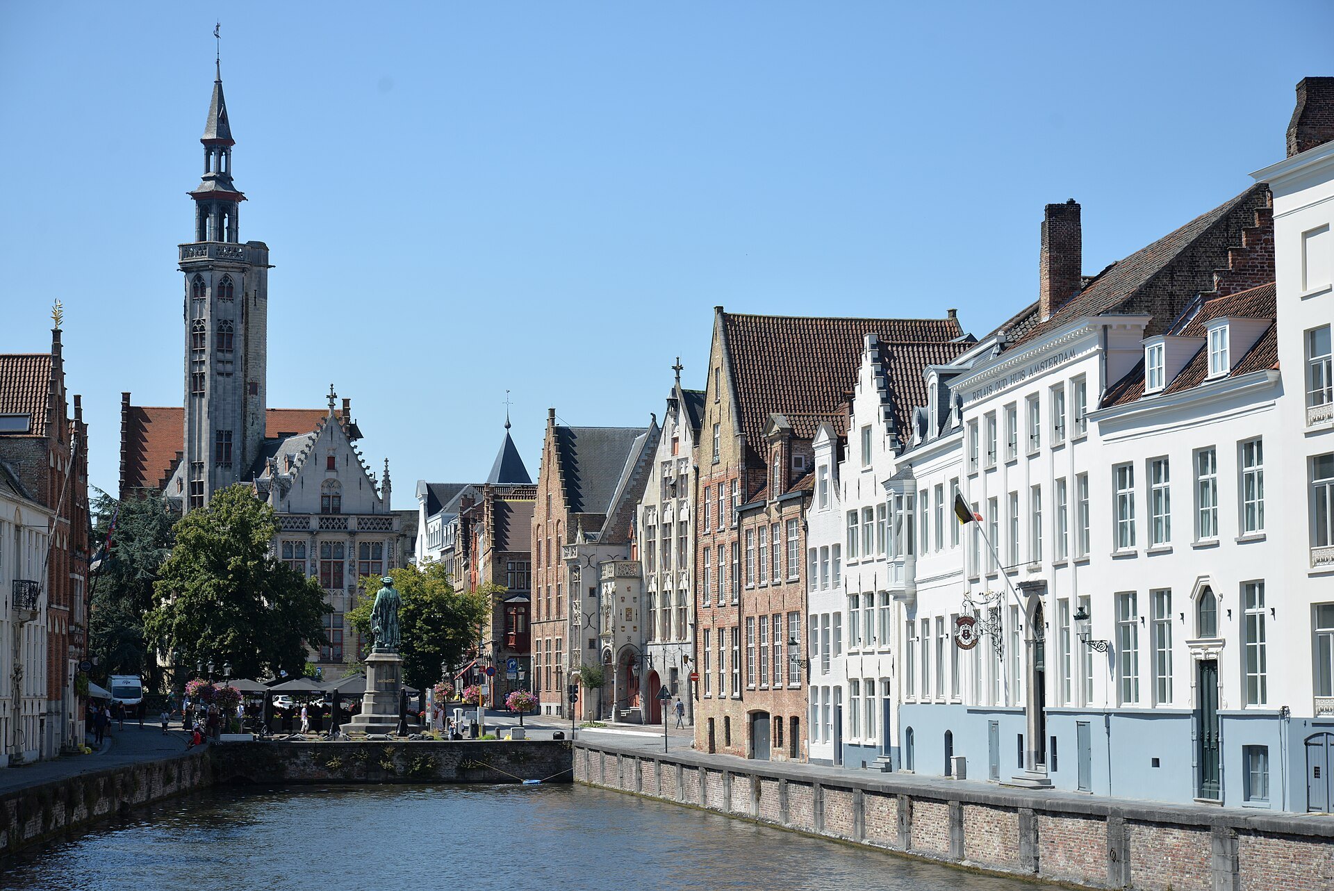Jan van Eyckplein from across the water, the slender tower of the Poortersloge rising over the square