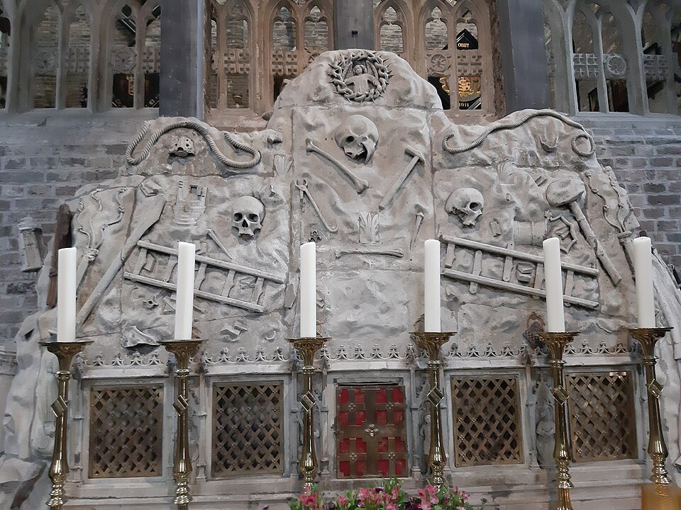 An altar carved with skulls, bones and ladders, candles along its top