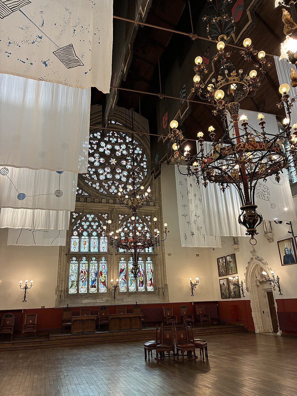A hall inside the Provincial Court, with a rose window and chandeliers
