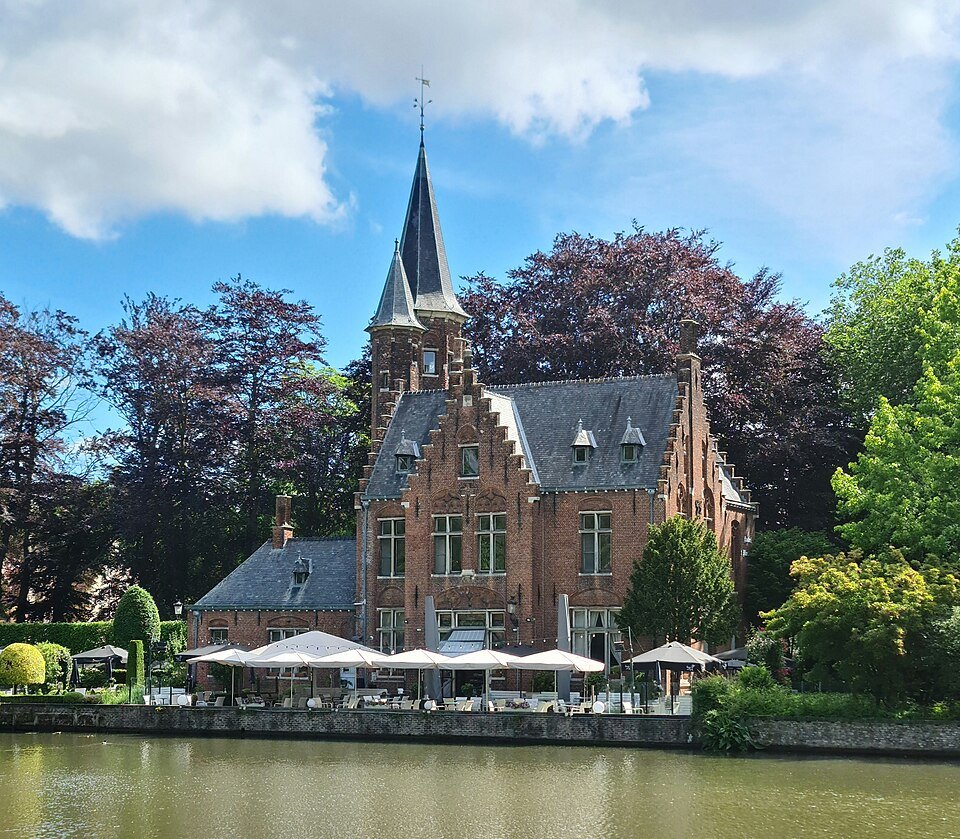 Kasteel de la Faille, a neo-Gothic brick house with a pointed tower, beside the lake
