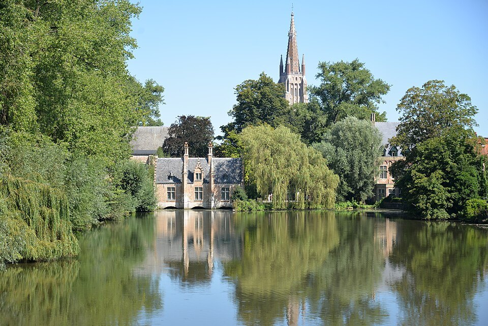 The lake and its willows, with the spire of Our Lady rising behind
