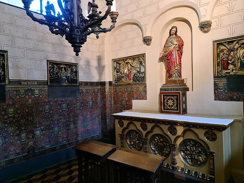 A tiled side chapel with a statue of Christ above the altar