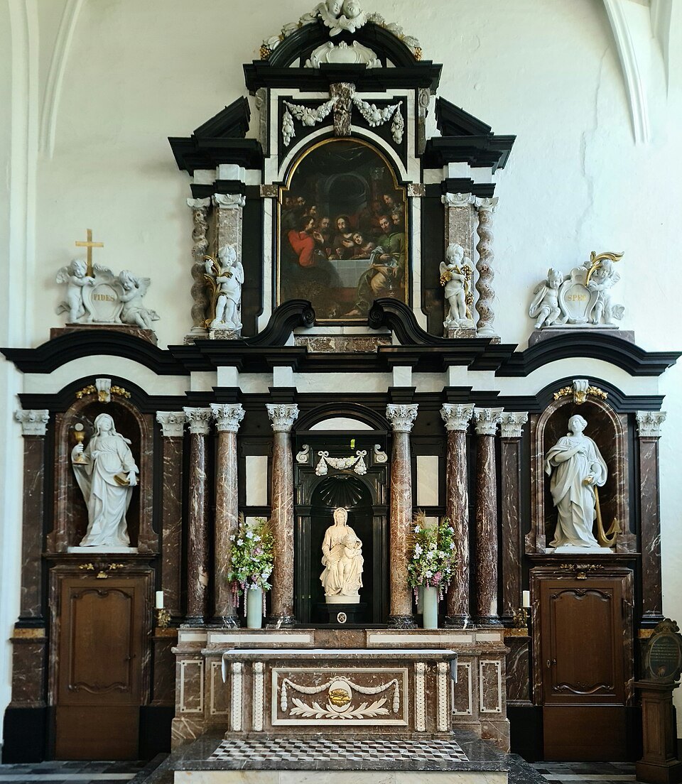 A black and white marble altar with statues on either side