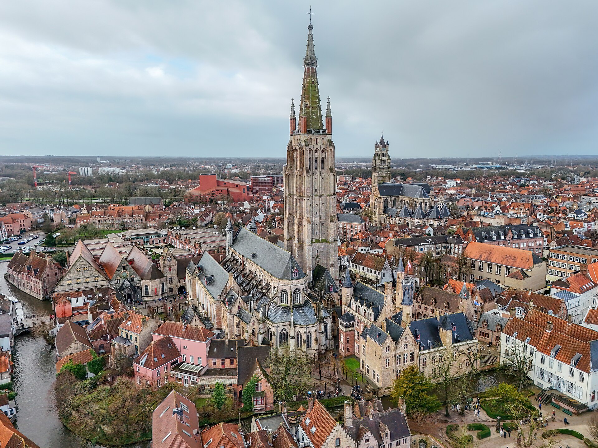 The brick tower and spire of Our Lady rising over the rooftops, seen from above