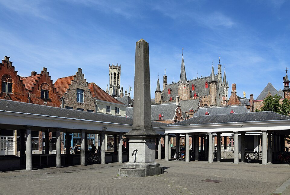 The colonnades of the fish market around a stone obelisk pump