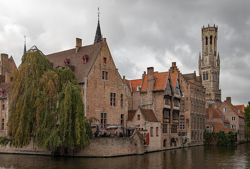 The classic bend of the Rozenhoedkaai, a willow on the left and the Belfry above the roofs