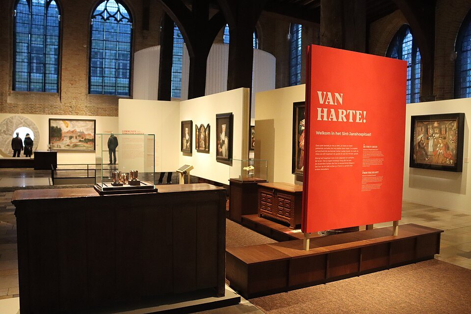 A museum room in the old hospital, with paintings and a red exhibition panel