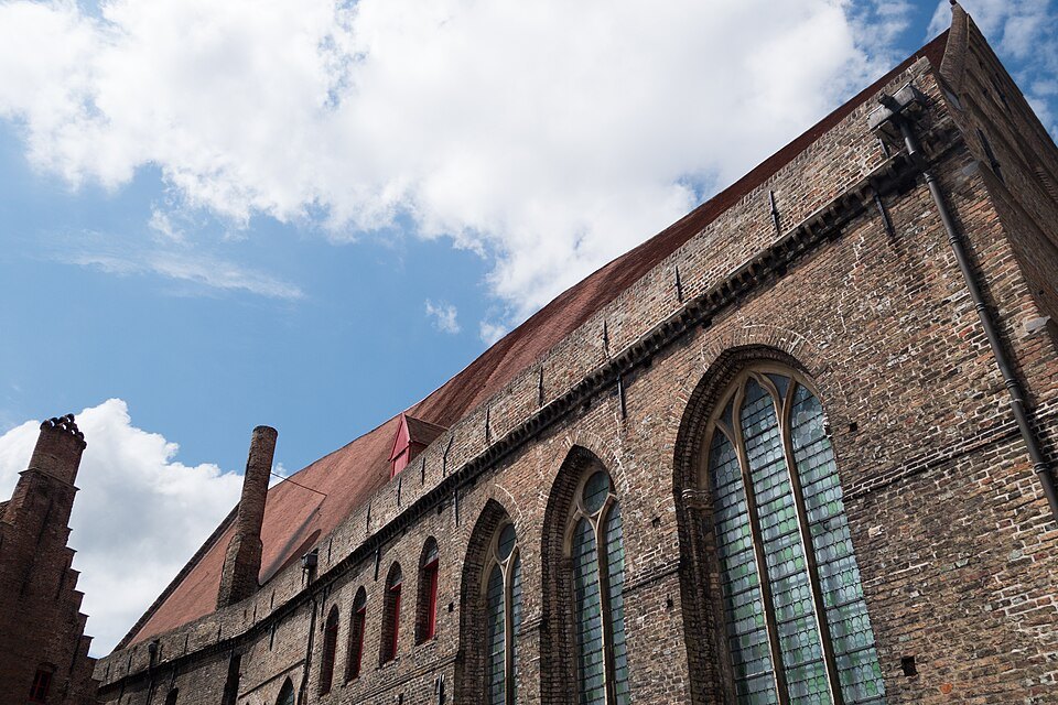 Tall Gothic windows in the long brick wall of the hospital