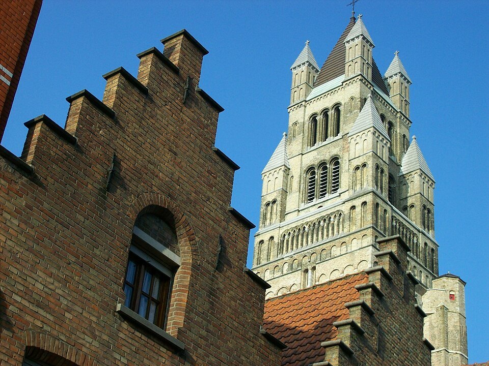 The top of the tower beyond a stepped brick gable