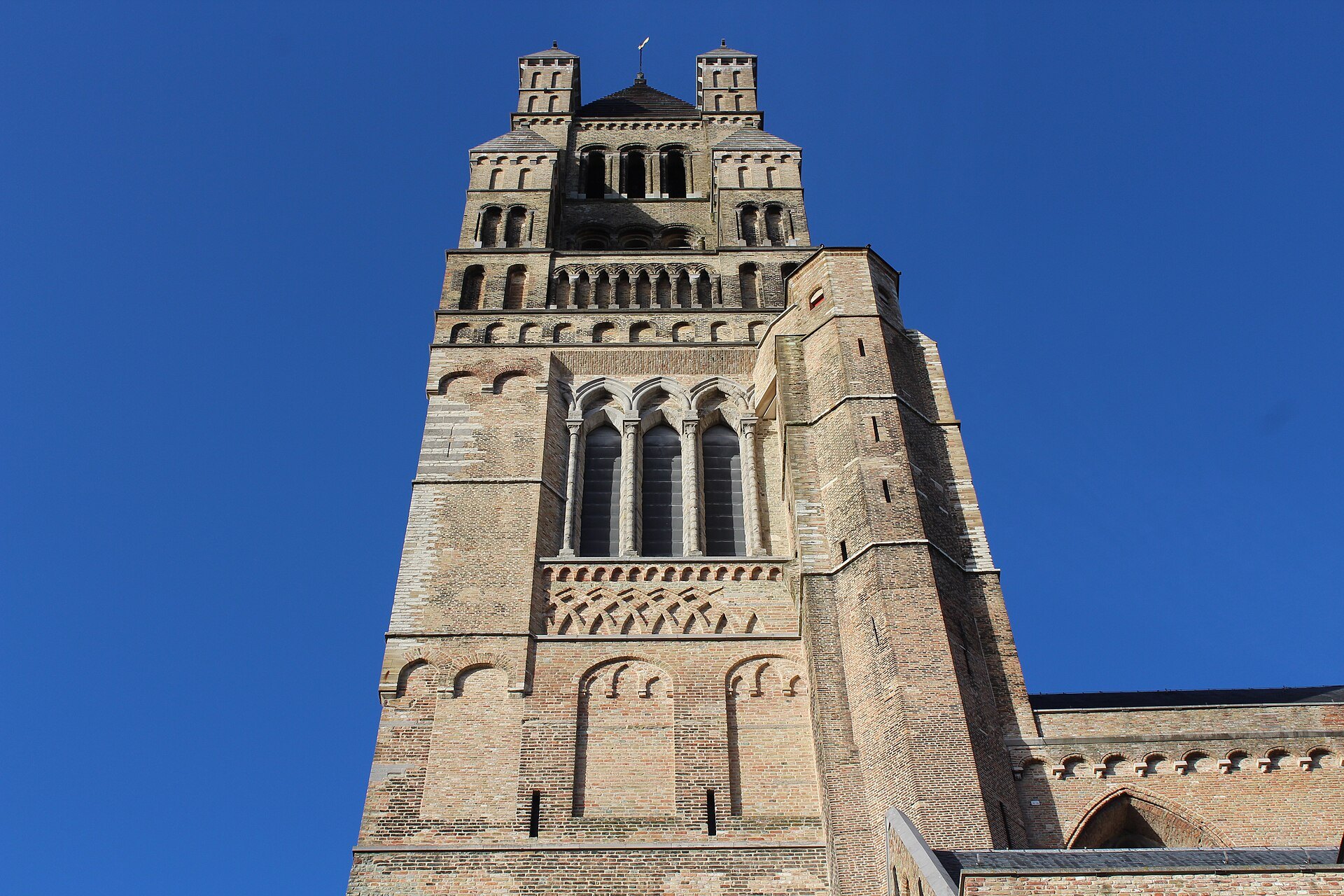 The heavy stone tower of St. Salvator's against a deep blue sky